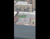 Two women sunbathing on the roof of a building 
