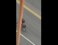 Guy rides on bicycle along street wear US flag