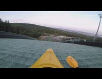 shirtless guy in yellow canoe down hill