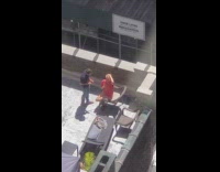 Blue shirt guy cuts ladys hair rooftop