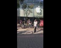 Man in sunglasses white shirt tries to copy dance of two guys in front of marimba at mall strip