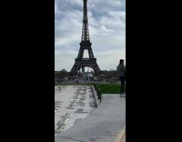 Couple kiss for photo by Eiffel Tower