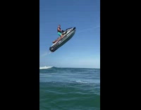 Guy jumps large wave white jet ski 