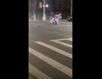 Guy holds bike while on back of motorcycle 