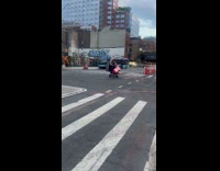 Woman carries large box while on scooter