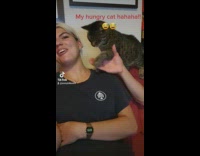 Cat tries to steal ladys snack 