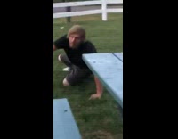 Guy backflips off blue bench table and lands on head on grass