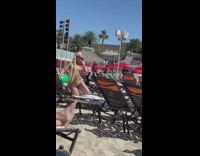 Lady in Brown Bikini Sits on Beach Chair for Photo 