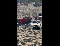Two men hug each other beach behind