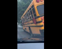 School bus raised tilted stuck on barrier