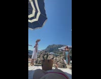 Woman white dress hat striped umbrella beach