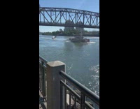 Sailboat capsized in river near the bridge