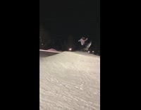 Snowboarder jumps over ramp and falls on back in snow