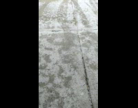 Snow on the garage yard cracks with salt