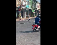 Woman crosses road with cup for video