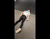 Friend laughs at guy laying on stomach on floor 