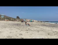 Girl laying back, relaxing at the beach, stranger sees her and tries to come closer to get her attention