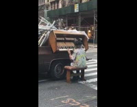 old woman plays piano from back of truck