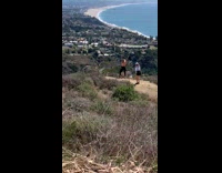 Woman topless hands in the air hill view