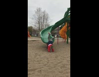 Boy goes down slide and does scorpion 