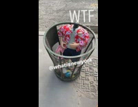 headless boy doll in trashcan on street red shirt