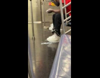 Man rub white liquid on sneakers inside train