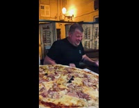 Guys order very large pizza  at restaurant