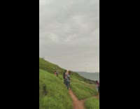 Guy shows beach view sunset grass hill 