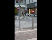 Woman in orange coat and green handbag walk