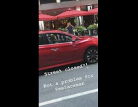 Maraca man in red car drives down closed street with police and plays maracas to music on stereo