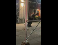 Shirtless man clown mask workout on scaffolding