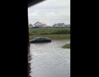 Black car stuck in deep flood water