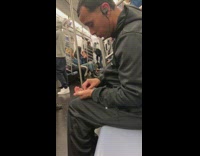 Man counts handful of pills and puts them inside pill bottle on lap on subway train 