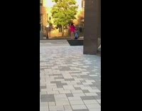 Woman pink red formal top poses at the sidewalk