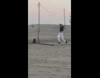 Guy black shirt kneel raise elbow beach