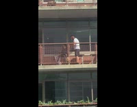 Guy cuts hair outside on balcony 