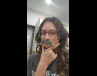 Woman wears cut out mustache from pizza box