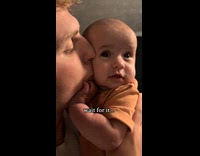 Baby tries to bite dads cheek