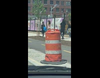 Model walking on sidewalk in bikini with photo crew