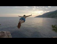 Guy jumps off cliff dives in ocean water