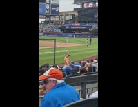 Girl orange top stand pose during baseball game