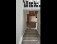 Lady laughs at baby behind wall stairs 
