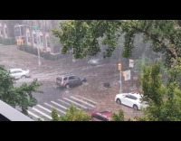 Car passed by man cleaning clogged drainage