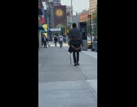 Guy with jacket tied on waist carries cane
