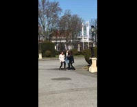 Three girls dance together lamp pole shrubs