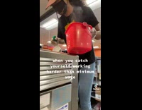 Girl cleaning grill with red bucket laughs to herself 