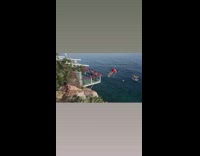 Guy runs dives off cliff ocean water