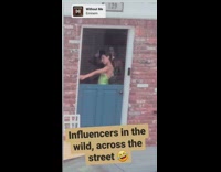 Two women in a dress tiktok dance beside the door