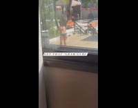 Woman with pink bra leans on the palm tree