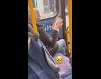 Woman on bus with picture of man in wood frame